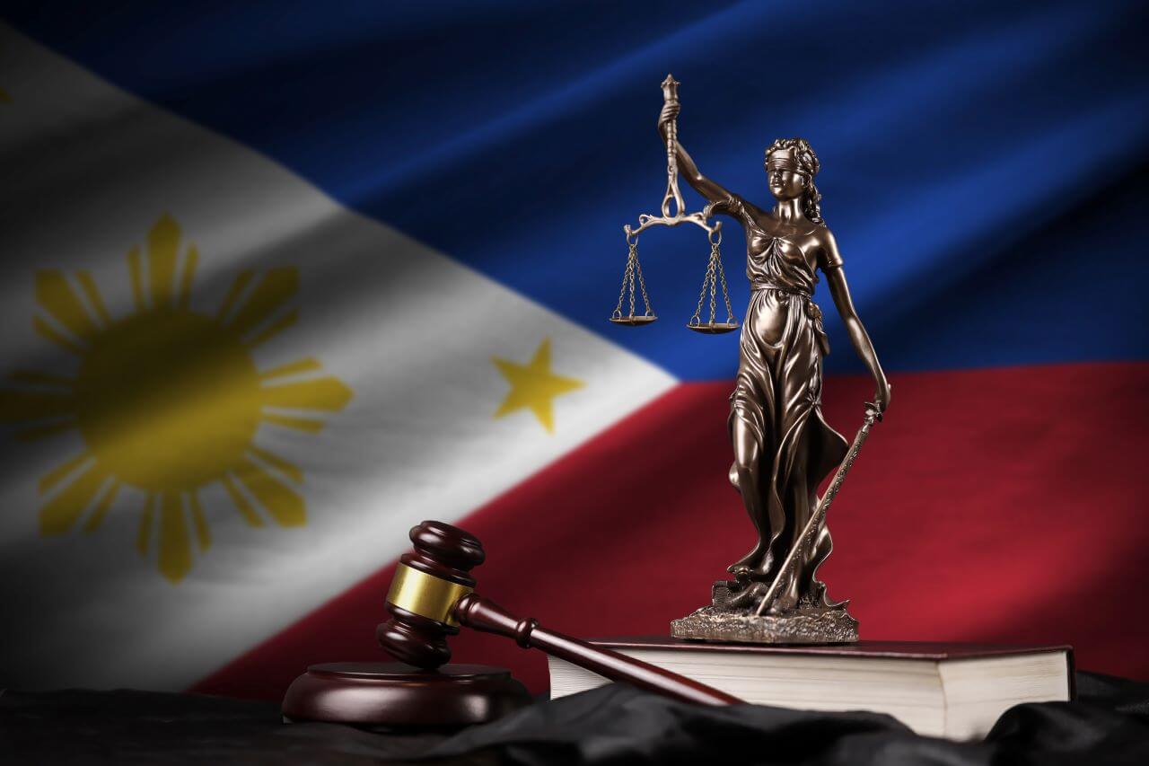 A statue of Lady Justice in front of the Philippine flag to represent the abstract concept of Philippines data laws.