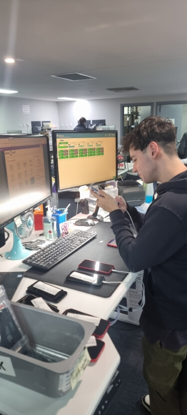 Technician using Blancco software to test and process smartphones as part of the IT asset recovery process.