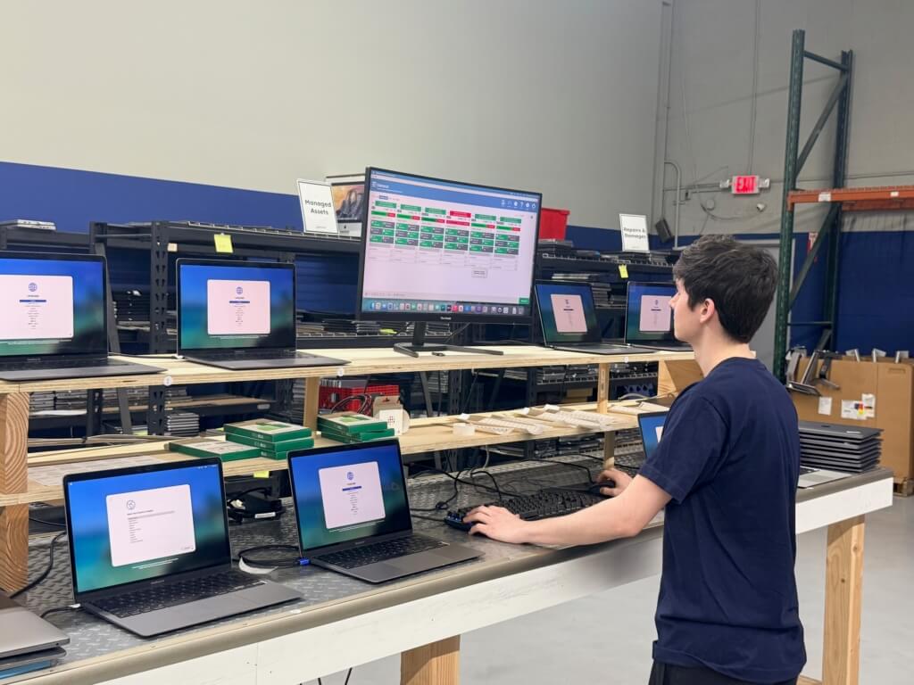 Upcycle technician using Blancco software to manage and process multiple laptops at a workstation in an IT asset disposition facility